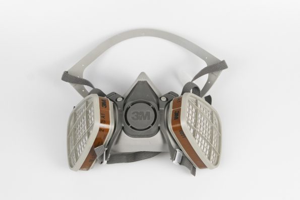 3M respiratory mask with dual filters and adjustable straps, designed for industrial safety and air filtration.